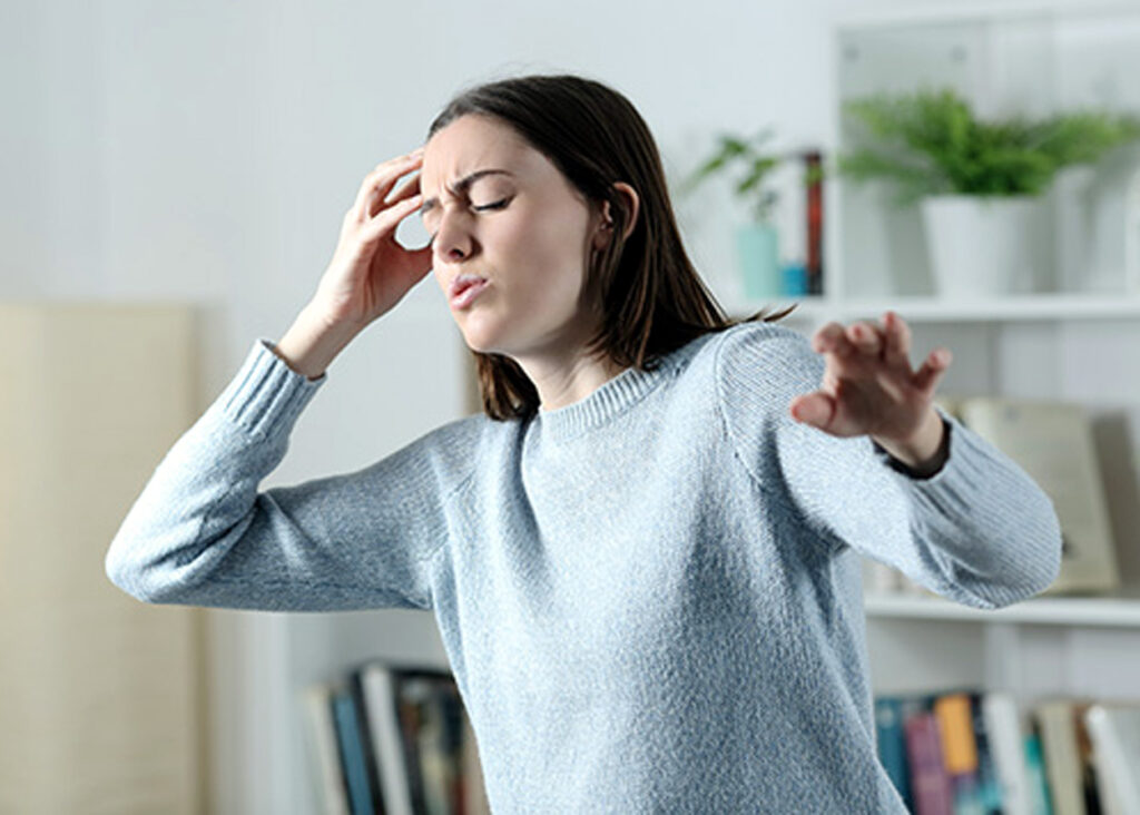 Dizzy woman suffering vertigo attack at home