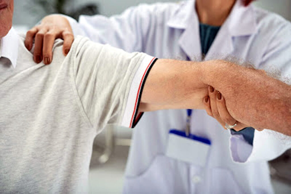 Senior man having shoulder and arm treatment in medical office